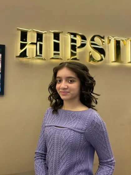 A cute and stylish look for a young client, with her hair styled in soft, face-framing curls.
