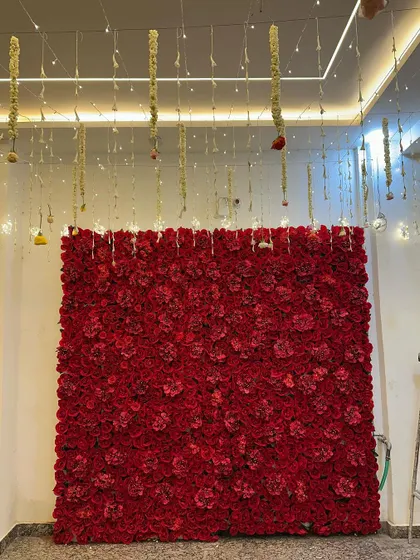Another shot of the red rose flower wall, showing how it can transform a simple corner into a vibrant and luxurious photo spot.