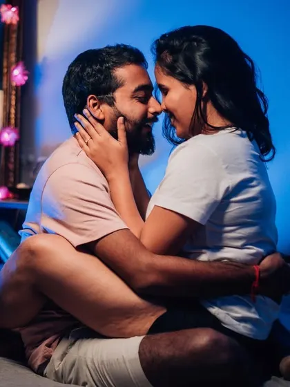 An intimate indoor pre-wedding photo, capturing a quiet and tender moment between the couple in a cozy setting.