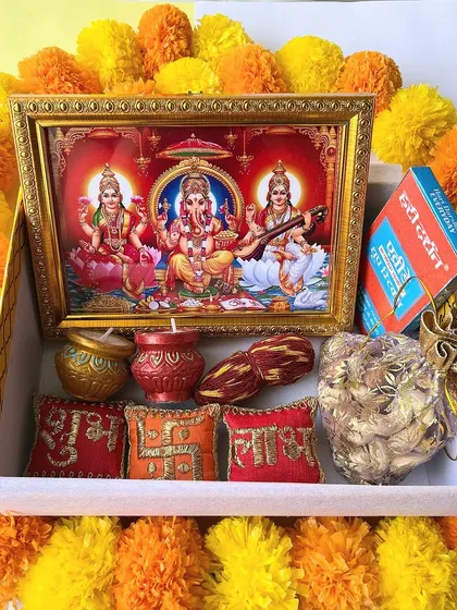 A look inside our Shubh Diwali hamper, surrounded by marigold flowers. It's filled with traditional goodies to celebrate the festival of lights.
