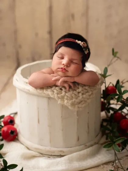 This little one looks so peaceful resting in a rustic white bucket. The pomegranate branches add a unique, artistic touch to this newborn portrait.