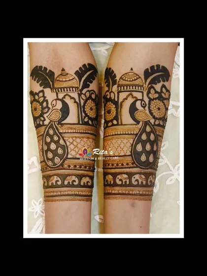 A close-up of the arm portion of the Maharashtrian bridal mehendi, highlighting the peacock and dome motifs.
