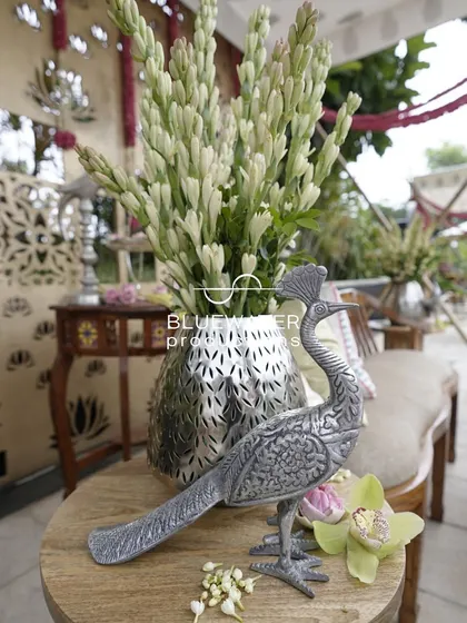 A close-up of a silver peacock statue, one of the many traditional props used to enhance the authenticity of a ceremony.