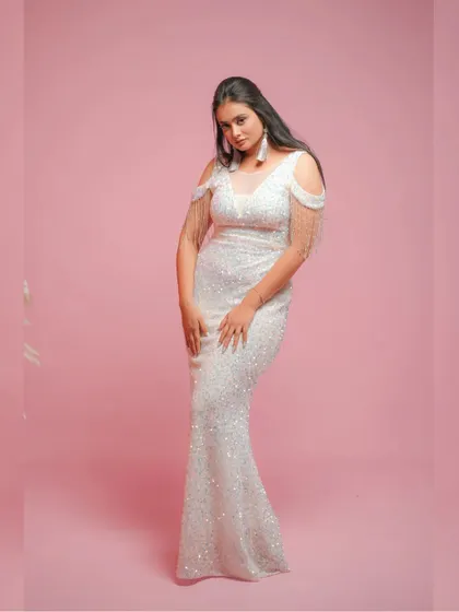 A full-length view of the white sequin dress against a soft pink background, creating a chic and modern vibe.