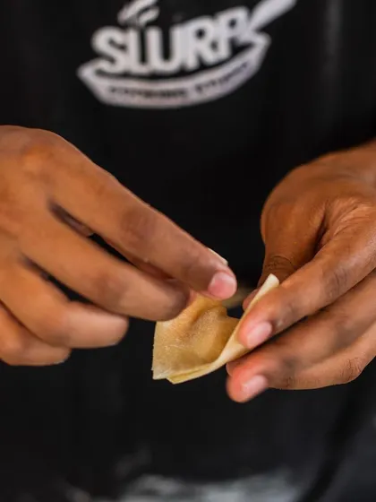 Precision in every fold. A student practices making dumplings, a skill that requires patience and attention to detail, as part of our 6-week certificate program.