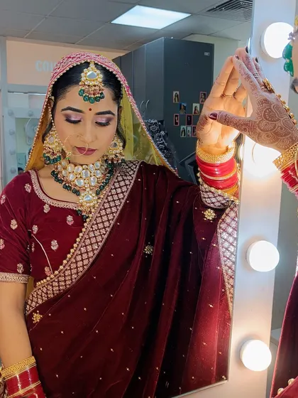 The bride admiring her reflection, a moment of confidence that our students strive to create with their artistry.