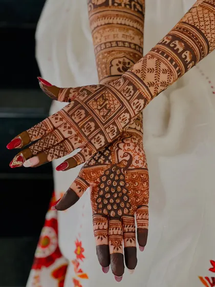 A close-up of the palm, showing a detailed peacock and grid pattern.