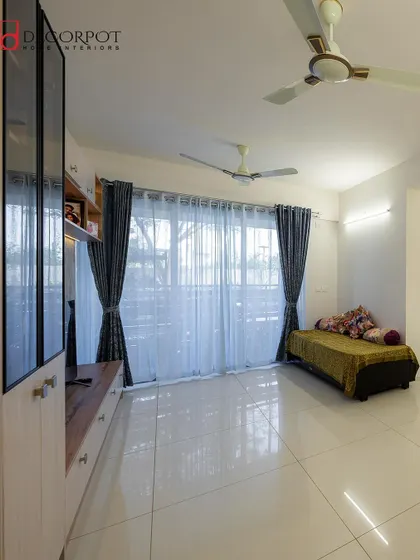 Another angle of the living space from image 120, showing the ample natural light from the large windows. The sheer curtains soften the light, creating a bright and airy atmosphere.