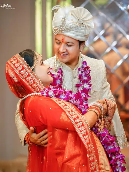 A joyful and candid moment between the couple. The groom lifts the bride in a playful embrace, and their laughter is absolutely infectious.