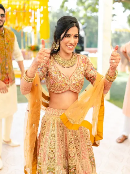 A fun and energetic shot from a Haldi ceremony. The bride's makeup is flawless and radiant, designed to look great even in action.
