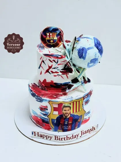 A football cake with an abstract, painted style in red, white, and blue. The design features an image of Lionel Messi and a 3D soccer ball on top.