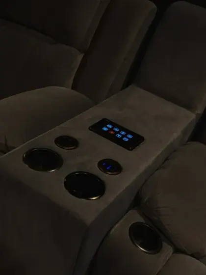 A wider shot of the automated recliners. The built-in cup holders and control panel make for a comfortable and convenient movie-watching experience.