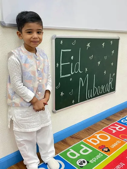 This young boy looks dapper in his traditional attire for the Eid celebration. We encourage children to dress up and fully immerse themselves in the festive experience.