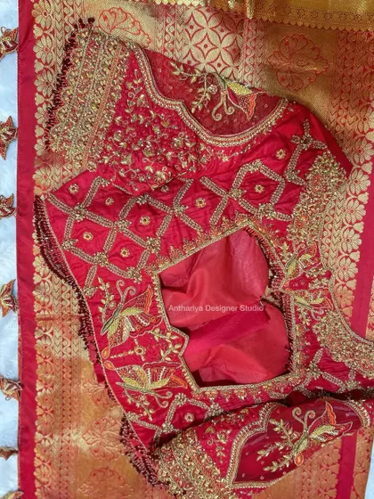 A stunning red bridal blouse with a unique back design featuring criss-cross patterns and bird motifs.