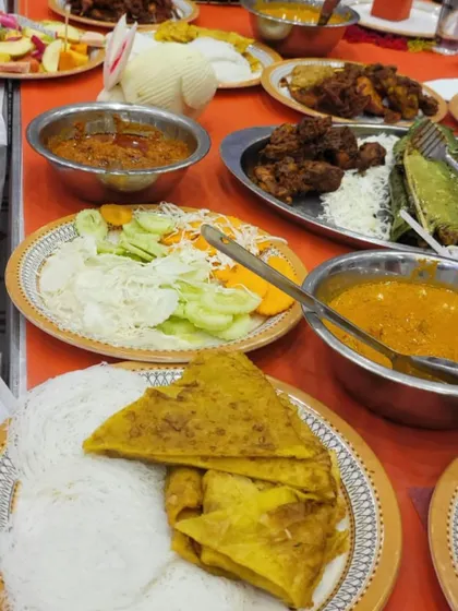 A table filled with a variety of dishes, including string hoppers (idiyappam), flatbreads, curries, and fried starters. This shows the diverse menu I can create for your event.