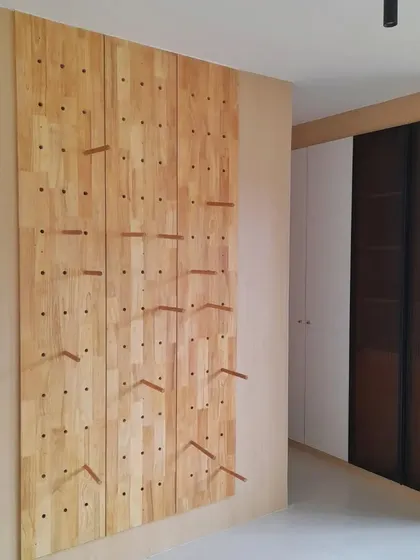 The final result of our perforated pine wood display system. After plenty of experimentation, we arrived at this design. We removed walls to let the circulation flow and used the perimeter for this unique, adjustable display, which perfectly matches our ideology.