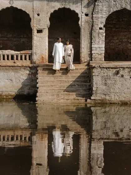 A stunning reflection shot at a historic stepwell, creating a perfectly symmetrical and timeless pre-wedding portrait.