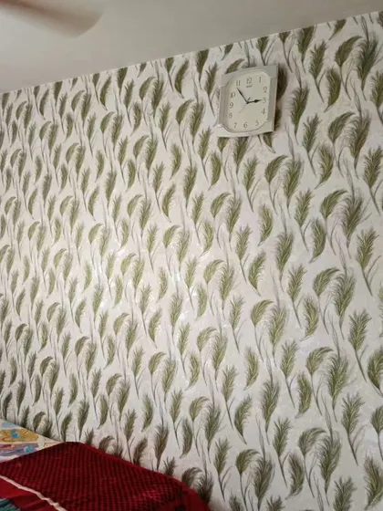 A similar feather pattern, this time in a soft green. This wallpaper adds a gentle, natural touch to the bedroom wall.