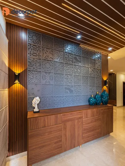 A full view of the artistic foyer unit, showcasing how the dark grey CNC panel, wood console, and rafter ceiling come together to create a dramatic and impressive entryway.