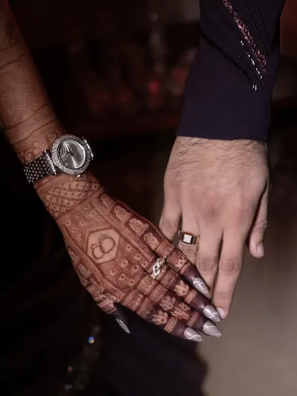 A beautiful shot of the couple holding hands after their engagement. The bride's dark mehendi stain looks so elegant next to her sparkling ring.