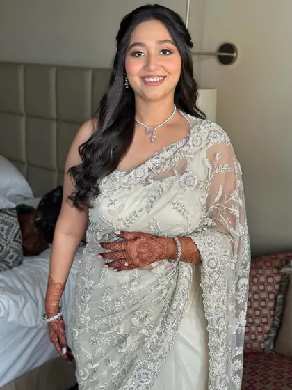 A full-length view of her elegant white saree. The soft glam makeup is the perfect complement to her sophisticated Roka outfit.