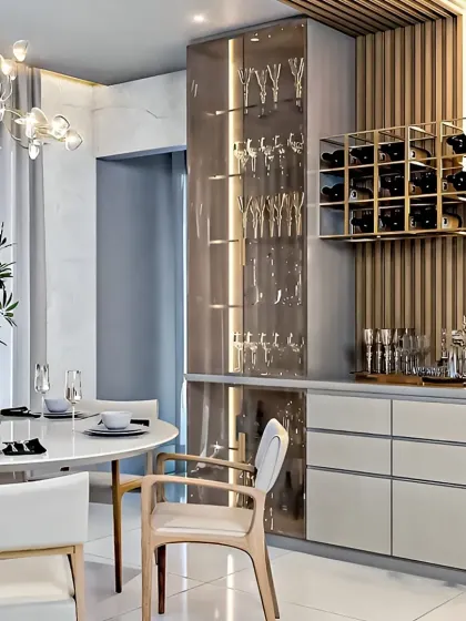 We created a dedicated bar and crockery unit for this dining space. The design includes a glass display for stemware, a built-in wine rack, and fluted wood paneling, adding a touch of luxury.