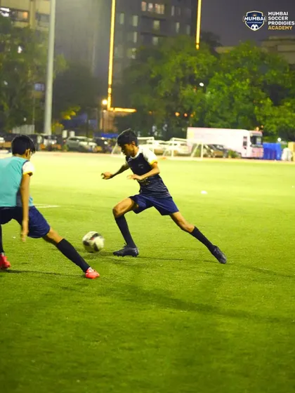 A player uses his body to shield the ball from an incoming defender in a competitive drill.