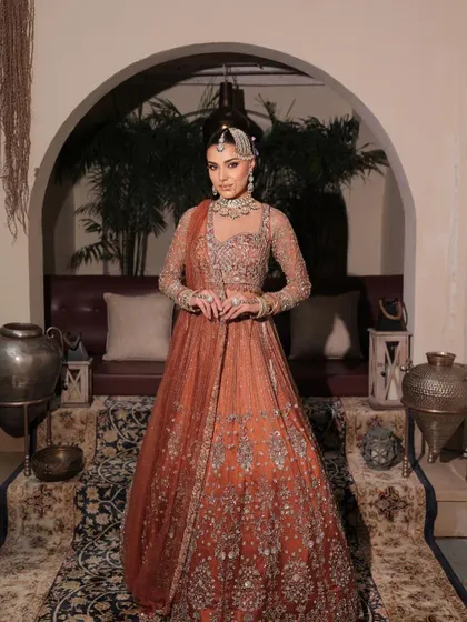 The full picture of a modern maharani. This rust-toned bridal outfit is paired with makeup that is both regal and contemporary, perfect for the bride who walks her own path.