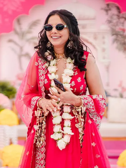 The perfect Haldi vibe! Shilpi's carnival look was modern and fun. Since she wore sunglasses for much of the event, we kept her eye makeup muted and let her radiant skin and stunning pink lehenga steal the show.