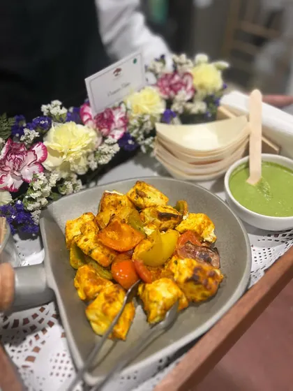 A server presenting our Paneer Tikka with green chutney. Our professional staff ensures that your guests are well taken care of throughout the event.