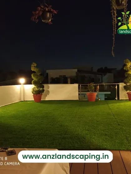 This night view of a terrace garden shows the impact of well-placed lighting. The warm globe lights and topiary plants create an inviting and sophisticated ambiance after dark.