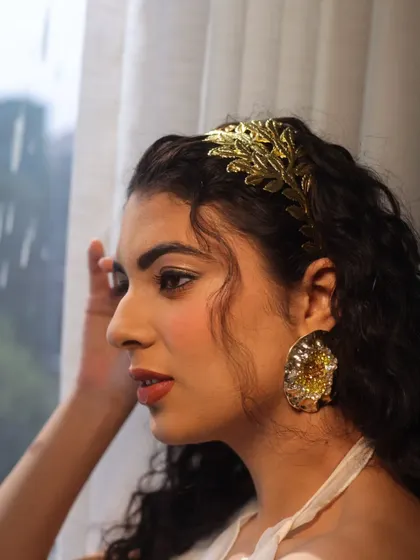 A profile shot highlighting the delicate makeup and the beautiful golden hair accessory. This is perfect inspiration for a subtle party look.