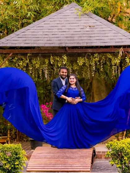 This wide shot showcases the full "wing" effect of the flowing blue gown. It's a powerful and symmetrical composition that makes for an unforgettable pre-wedding picture.