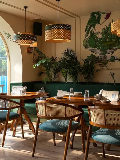 For this vibrant cafe space, I designed and built these mid-century modern dining chairs with natural cane weaving and teal upholstered seats. The solid wood chairs are paired with custom dining tables, creating a cohesive and inviting atmosphere for patrons.