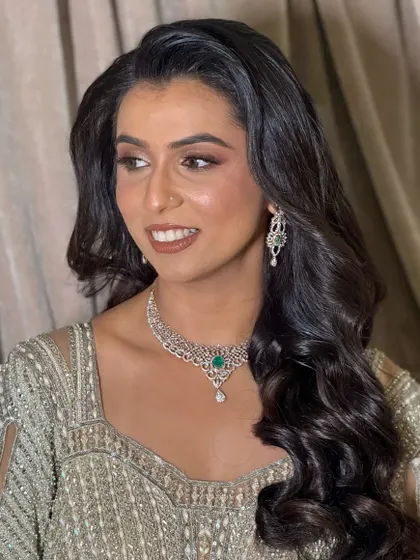 A close-up of the client's smiling face, her makeup looking flawless and radiant.