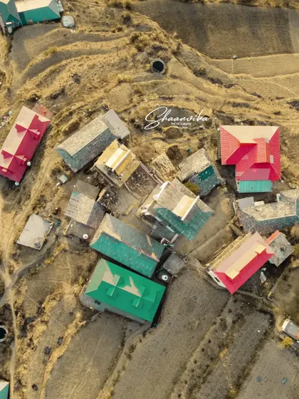 A top-down drone shot of the village and temple complex of Dharech. This perspective reveals the unique layout and architecture of a traditional Himachali village.
