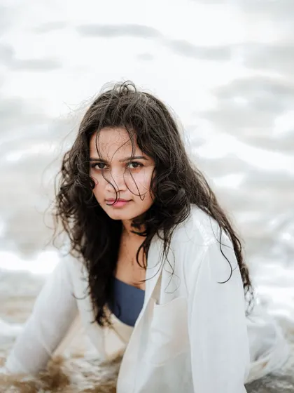 A beautiful, intimate portrait with wet, curly hair framing the model's face. The soft light and close crop create a very personal and engaging photo.