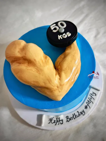 A bicep cake for a fitness freak celebrating his "fit fifty" birthday. The bicep is carved from cake!
