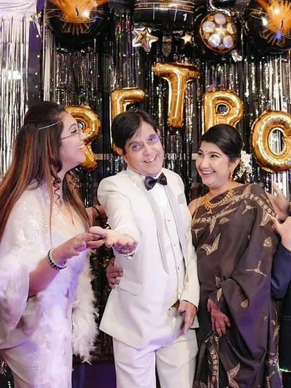 A candid family moment at the retro party, filled with laughter and fun interactions.