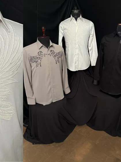 This image displays three distinct embroidered shirt styles: the white eagle, the beige winged horses, and a black shirt with abstract floral embroidery, each telling its own story.