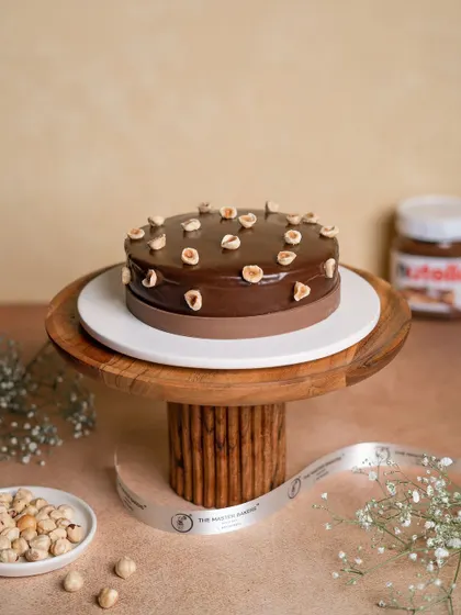 This is a chocolate and hazelnut lover's dream. Our cake is layered with moist chocolate sponge and a silky hazelnut-infused cream, then topped with a rich chocolate ganache and whole roasted hazelnuts.