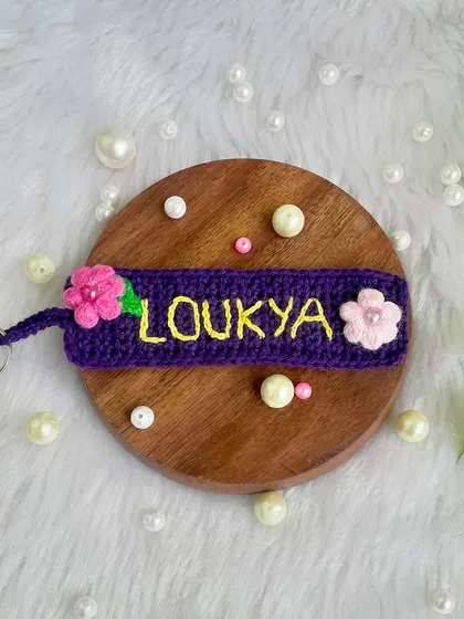 A personalized name keychain I made for a returning customer. The name is embroidered onto a crochet tag and decorated with little pink flowers.
