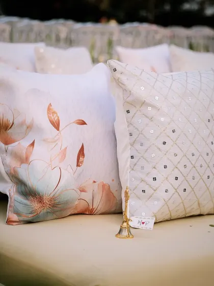Custom cushions for a welcome dinner, one with a floral print and the other with sequins, adding a touch of personality and glamour.