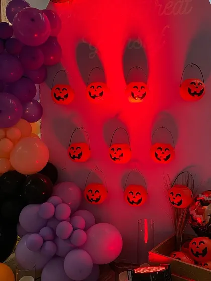A wall of glowing jack-o'-lantern buckets at a Halloween party. This creative and spooky lighting element adds to the festive and eerie atmosphere of the event.