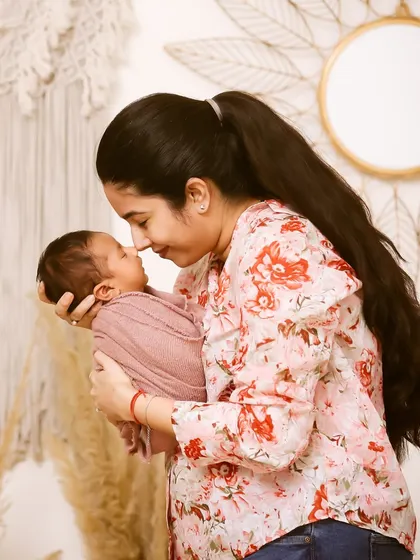 The pure love between a mother and her newborn. She holds her baby close, their faces touching, in a beautifully lit studio portrait.