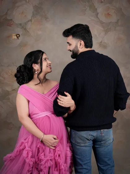 A candid moment of love. The couple shares a private smile, with the floral backdrop adding a touch of romance to this sweet, unposed shot.