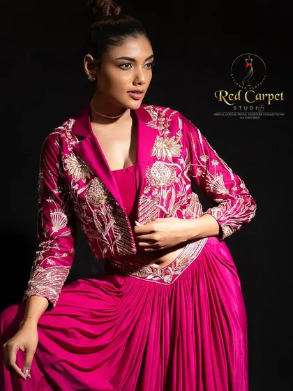 A close-up of the detailed gold embroidery on the fuchsia pink jacket. The craftsmanship adds a luxurious texture and shine, making it a true statement piece.