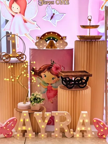 A close-up of the decor from Ayra's fairy-themed first birthday, showing the detailed props on corrugated pedestals.