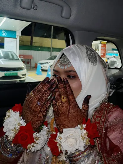 The bride's hands, with their rich henna stain, are the highlight of this candid moment.