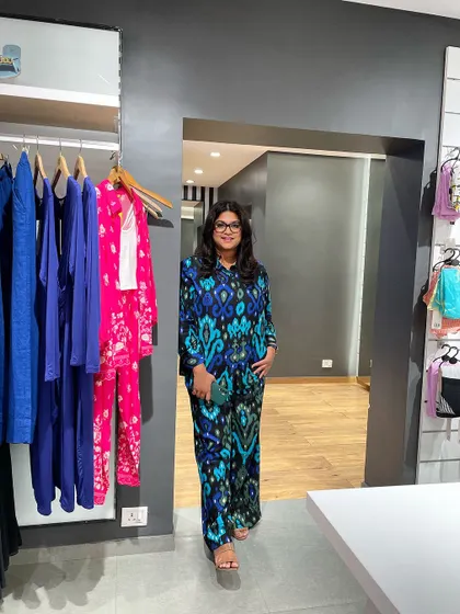 The stylist poses in a store wearing a blue and green ikat print co-ord set.